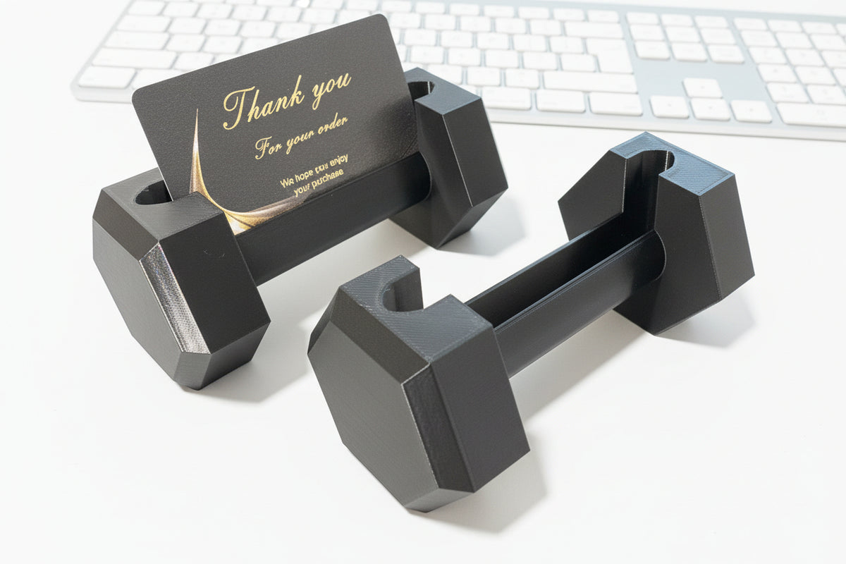 Black dumbbells on a desk with a keyboard in the background